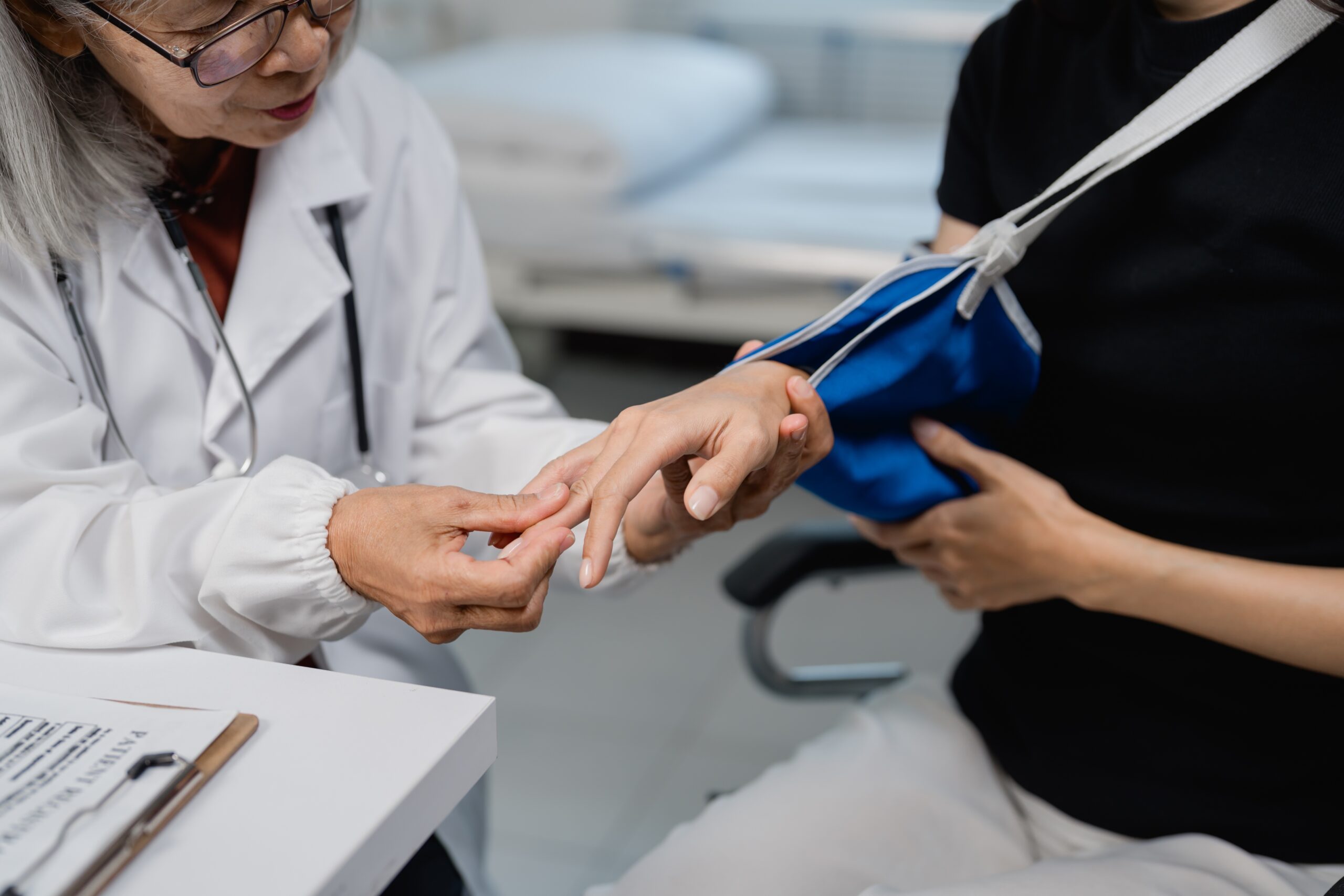 Medical professional examining an injured workers hand and wrist in a clinic