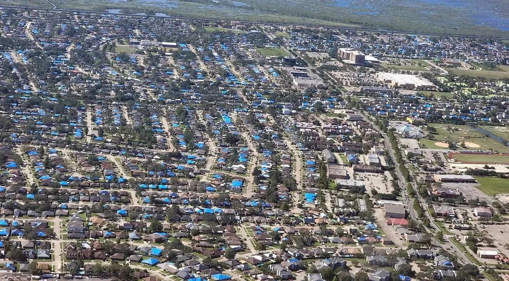 Aerial view of a Louisiana neighborhood with hundreds of blue-tarp roofs after Hurricane Ida